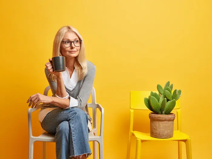 Woman holding a coffee cup, representing a guide on how to sell your home via auction with Under the Hammer
